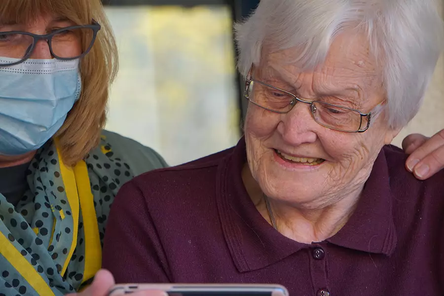 An elderly woman looks at an iPhone